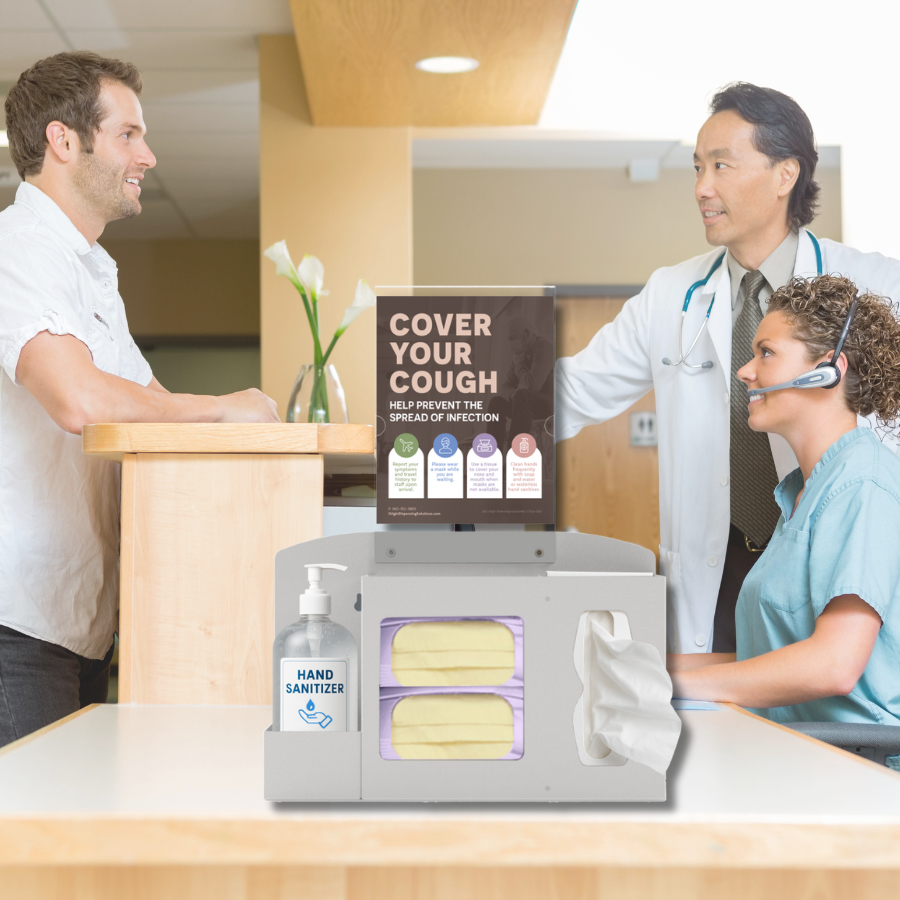 Male patient at reception desk speaking with male doctor and female nurse with an ORIGIN Hygiene Station on the counter and a COVER YOUR COUGH sign in the sign holder.